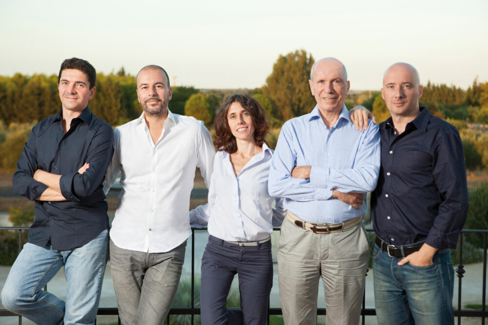 Five adults smiling on balcony